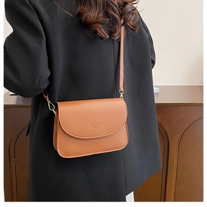 Sac bandoulière marron avec imprimé Fashion Bags porté sur une veste blazer noire