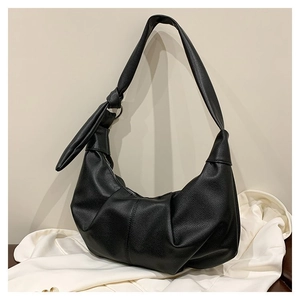 Detail of black lychee texture leather bag with elegant knot strap and ruched pleated bottom