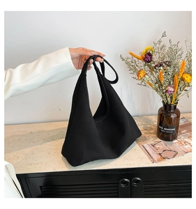 Dettaglio di una grande borsa tote nera vintage opaca con tracolla larga per uso quotidiano