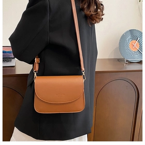Sac bandoulière en cuir marron avec sangle réglable porté par un mannequin à domicile
