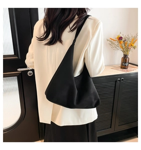 Grande borsa hobo nera opaca minimalista abbinata a un blazer bianco per il lavoro