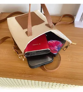 Interior detail of two-tone crossbody bag showing capacity for two phones and power bank