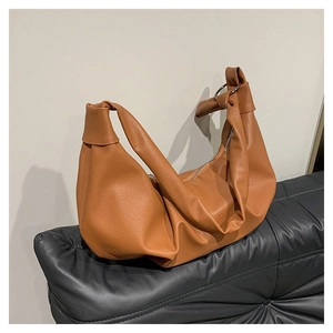 Detail of soft pleated brown hobo bag with knotted strap and silver ring buckle