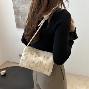Minimalist beige crossbody straw bag with floral embroidery and thin shoulder strap