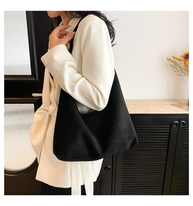 Dettaglio della borsa tote nera opaca con tracolla larga e silhouette a forma di mezzaluna