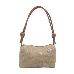 Minimalist beige woven pillow bag with floral embroidery and adjustable rope shoulder strap