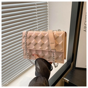 Detail of 3D pyramid quilted pattern and silver chain strap on the nude pink crossbody bag