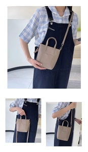 Detail view of beige lychee texture leather handbag with removable strap and front pocket