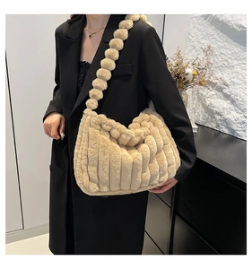 Detail of plush tote bag featuring soft beige faux fur and fuzzy pom-pom shoulder strap