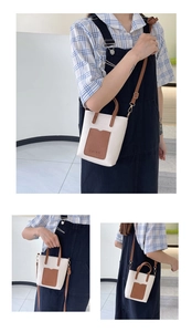 Detail of contrast color crossbody bag featuring lychee grain leather and fashion embossing
