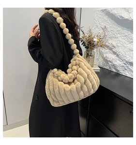 Detailed view of plush beige tote bag with a unique fuzzy ball strap and striped fur texture