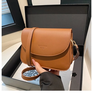 Détail du sac à bandoulière en similicuir caramel avec texte de mode embossé