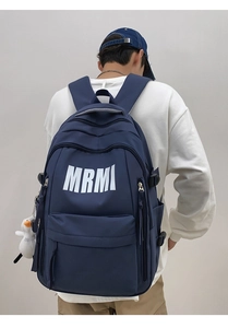 Detail of navy blue sports backpack with white MRMI logo and cute duck pendant accessory