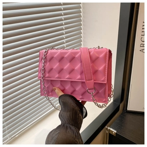 Detail of pink crossbody bag with geometric diamond quilting and silver chain strap