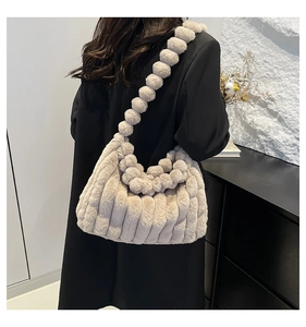 Detail of beige plush tote bag with vertical stripes and spherical beaded strap