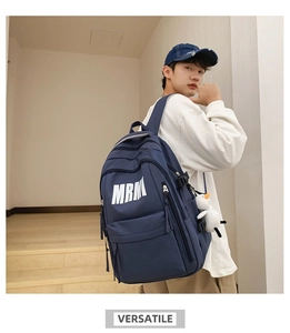 Detail of navy blue student backpack with MRM logo and white bird plush charm