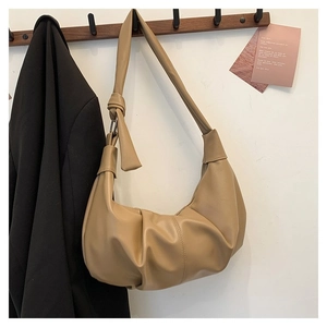 Detail view of khaki pleated dumpling bag with textured leather and knotted handle design