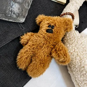 Close-up van een bruine pluchen berenhanger met zacht imitatiebont en siliconen band