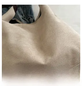 Detail of soft beige faux suede tote bag with wide shoulder strap for daily commuting