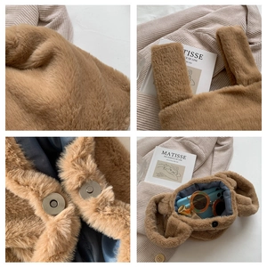 Detail showing plush brown faux fur texture and magnetic snap closure on the small handbag