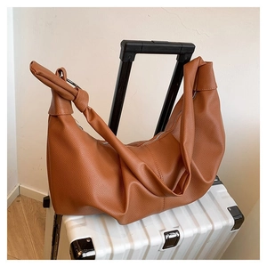 Detail of soft brown pebble leather hobo bag with stylish knotted shoulder strap detail