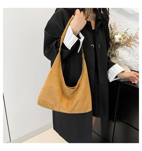 Dettaglio della borsa tote grande in camoscio caramello con trama opaca e tracolla integrata