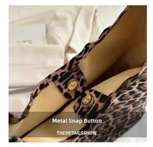 Detail view of the magnetic hardware clasp and beige fabric lining of leopard tote bag