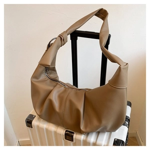 Close-up of khaki pleated dumpling bag with lychee grain texture and metal zipper