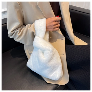Détail du sac à main en peluche blanche avec poignée nouée et texture douce en fausse fourrure