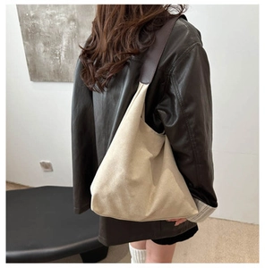 Detail view of large minimalist canvas tote bag with brown leather straps for commuting