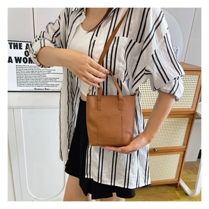 Brown litchi grain leather mini tote bag with handle and crossbody strap detail