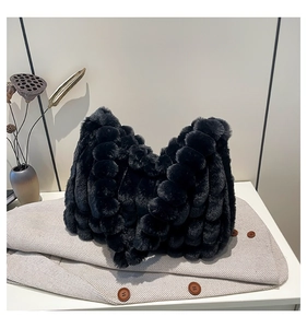 Close-up of black plush tote bag with textured faux fur on a stylish herringbone coat