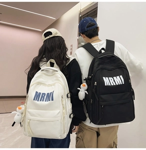 Detailed view of large capacity nylon backpack with MRMI logo and plush duck charm