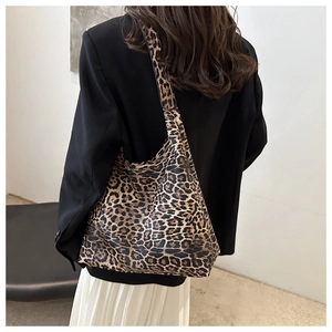Detail view of large leopard print tote bag styled with a professional black blazer