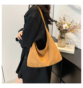 Borsa hobo marrone in pelle scamosciata indossata a spalla, focus su morbidezza