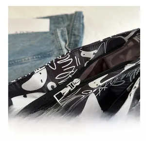 Close-up of the smooth metal zipper and black and white graffiti canvas fabric details