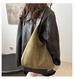 Detail view of large olive green suede tote bag showing wide shoulder strap and texture