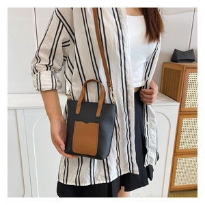 Detail of minimalist two-tone leather crossbody bag with FASHION lettering