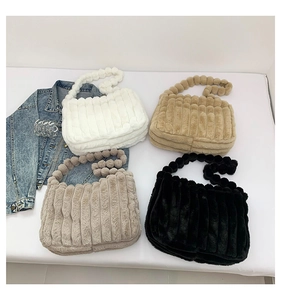 Detailed view of plush tote bags with fluffy ball handles and vertical striped texture