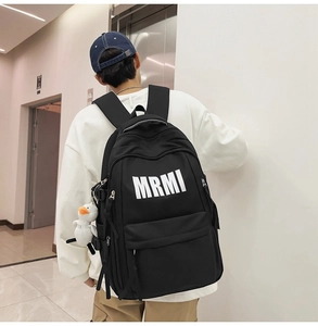 Detail of black waterproof backpack with MRMI logo and white duck plush keychain