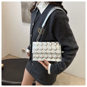 Detail of silver quilted crossbody bag with metallic finish and chic chain shoulder strap