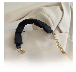 Detail of black pleated cloud bag featuring thickened padded handle and gold chain strap