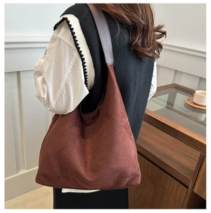 Deep brown suede hobo bag shown in side-back view on a model for daily commute style