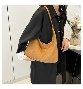 Vista dettagliata della trama della borsa tote in pelle scamosciata marrone e cuciture