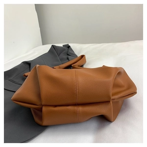 Detail view of brown pleated faux leather texture on soft casual shoulder bag