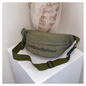Gros plan du sac banane en nylon vert olive avec logo et tirette de fermeture éclair tissée