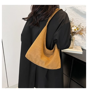Borsa hobo gialla senape retrò abbinata a un cappotto nero lungo per un look chic quotidiano