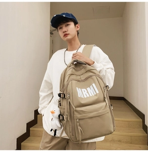 Detail of khaki large capacity backpack with MRMI logo print and duck plush charm