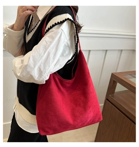 Detail view of large red velvet hobo shoulder bag styled with minimalist vintage outfit