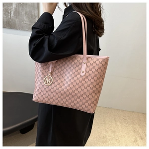 Detailed close-up of pink leather tote bag with M-letter print and golden charm